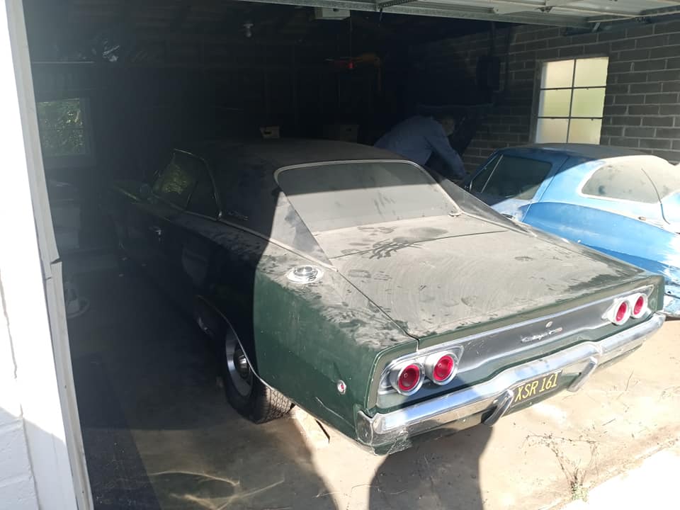 Dusty old cars in a brick garage